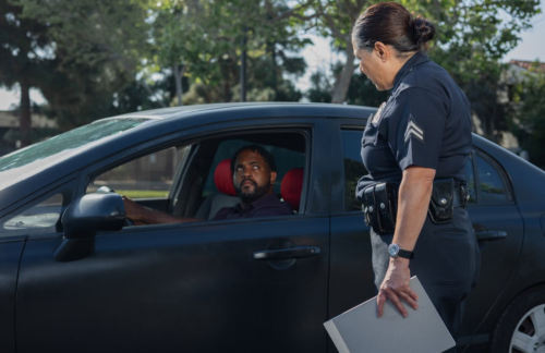 Officer questioning a man driving a car