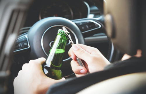 Person opening a bottle while driving