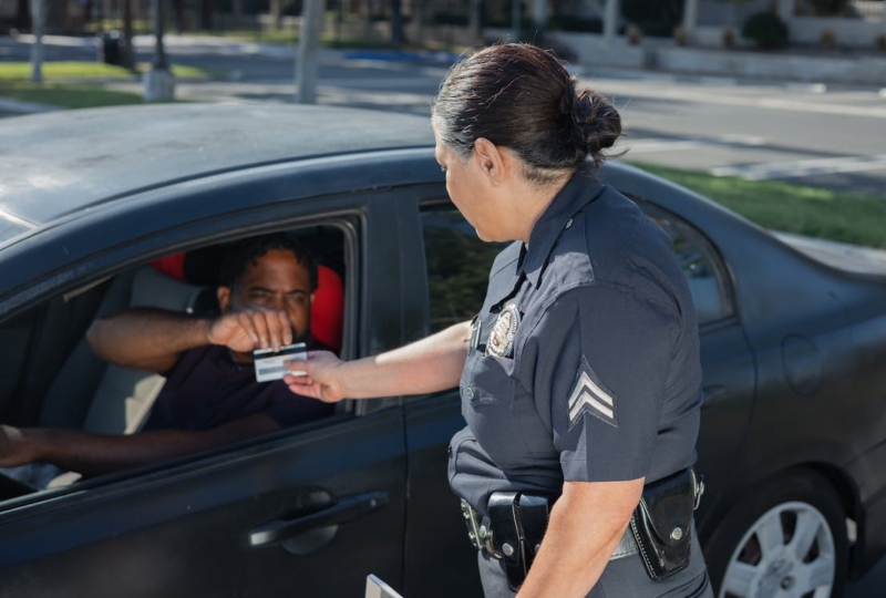 Officer checking a man&rsquo;s driver&rsquo;s license