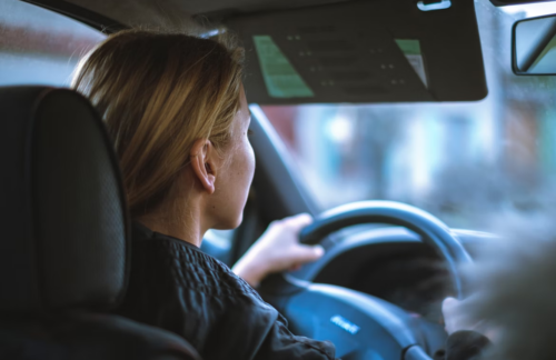 A young woman driving a car with Virginia FR-44 insurance.