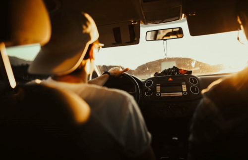 A male driver driving into the sun.