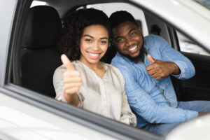 Two happy people gesturing thumbs up after getting driver's license reinstated with FR44 DUI insurance.