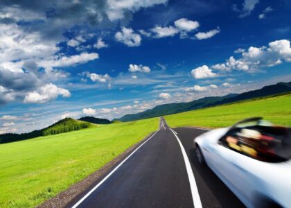 New car with the required insurance coverage traveling down a road.
