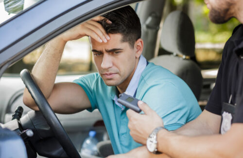 Young man in car is pulled over by police for DUI and will need Minnesota SR22 insurance.