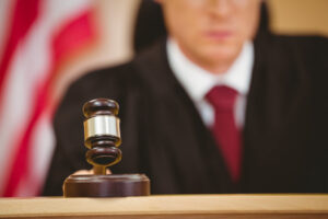 Serious judge in courtroom pounding his gavel in a court case involving Minnesota DUI.