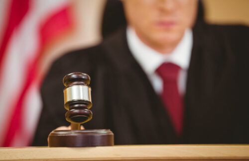 Serious judge in courtroom pounding his gavel in a court case involving Minnesota DUI. 