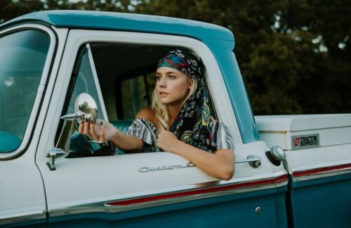 A young woman who maintains SR-22 insurance in Oregon.driving a vintage truck.