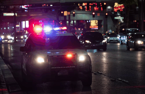 A police car with siren lights on making a DUI stop on a Florida street at night.