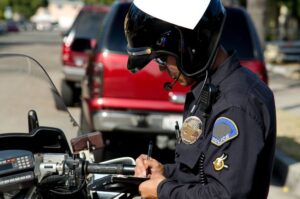 A motorcycle cop writing a ticket to a driver for violating the Tennessee hands-free driving law.