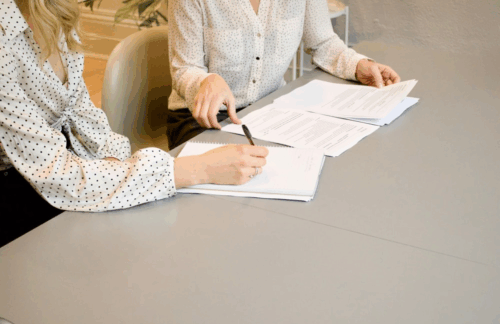 A woman signing Oregon SR-22 paperwork with her insurance agent .