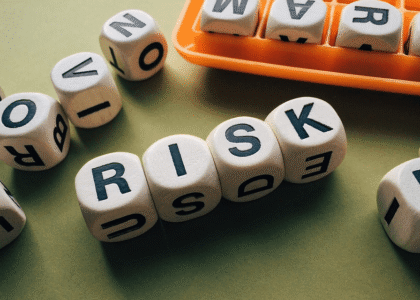 A photo of dice spells the word RISK, depicting factors that affect Oregon SR22 insurance rate quotes for drivers.