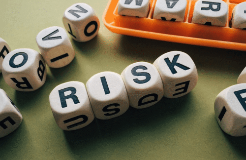 A photo of dice spells the word RISK, depicting factors that affect Oregon SR22 insurance rate quotes for drivers.