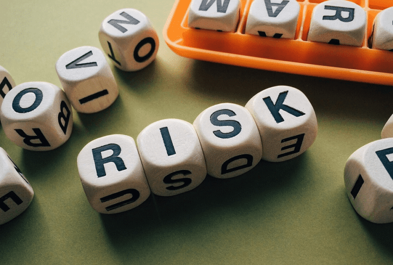A photo of dice spells the word RISK, depicting factors that affect Oregon SR22 insurance rate quotes for drivers.