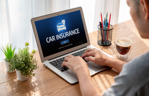 A man uses a laptop to research how to file SR22 car insurance in Tennessee.