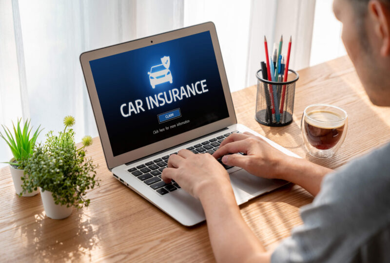 A man uses a laptop to research how to file SR22 car insurance in Tennessee.
