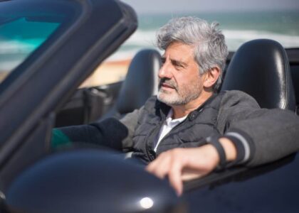 A middle-aged man with gray hair is driving a convertible with a lapsed Tennessee SR22 insurance policy.